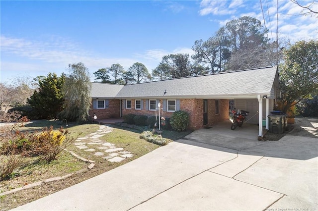 single story home featuring an attached carport, concrete driveway, and brick siding