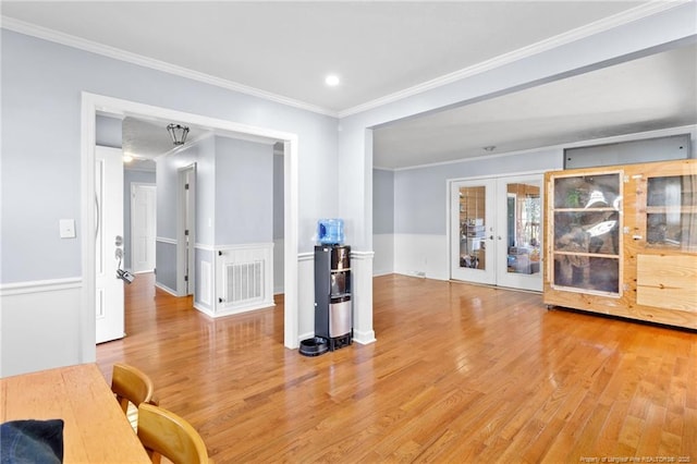 interior space featuring light wood-style floors, visible vents, crown molding, and french doors