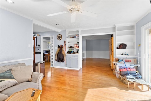 living area with light wood-type flooring, built in shelves, and a ceiling fan