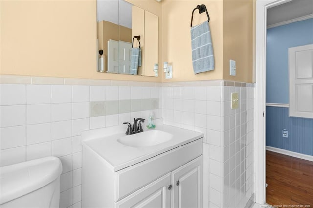 bathroom featuring a wainscoted wall, vanity, toilet, and wood finished floors