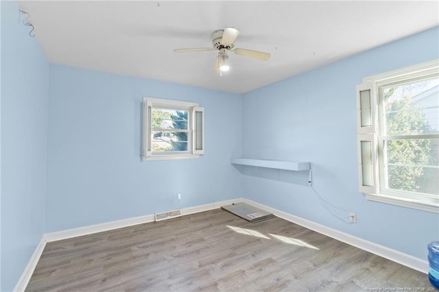 spare room featuring visible vents, plenty of natural light, and baseboards