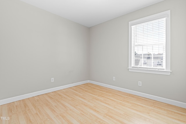 empty room featuring wood finished floors and baseboards