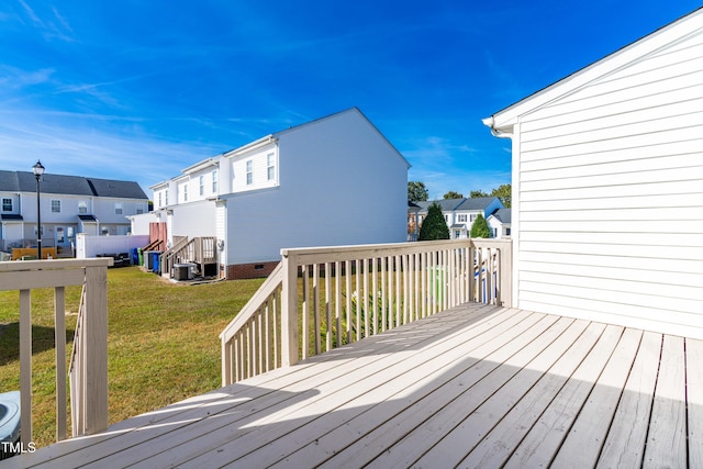 wooden deck featuring a residential view and a yard