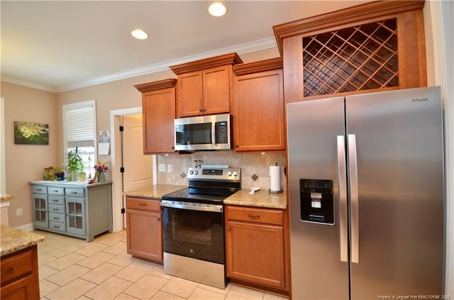 kitchen with stainless steel appliances, light stone countertops, crown molding, and tasteful backsplash