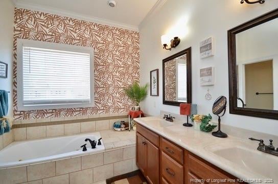 full bath with double vanity, crown molding, a sink, and a bath