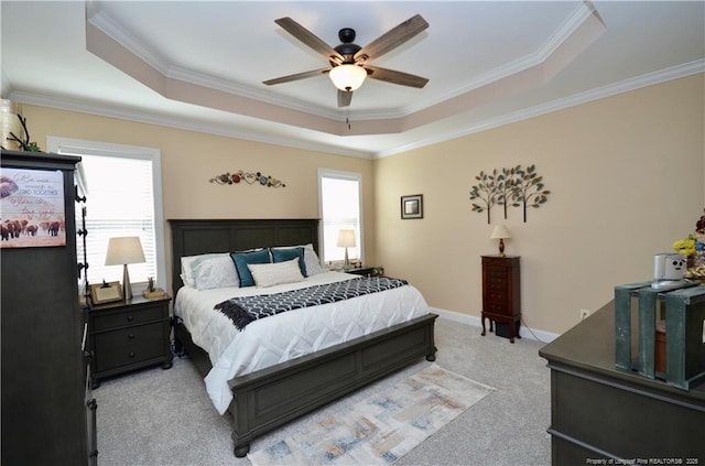 bedroom with ornamental molding, a tray ceiling, and baseboards