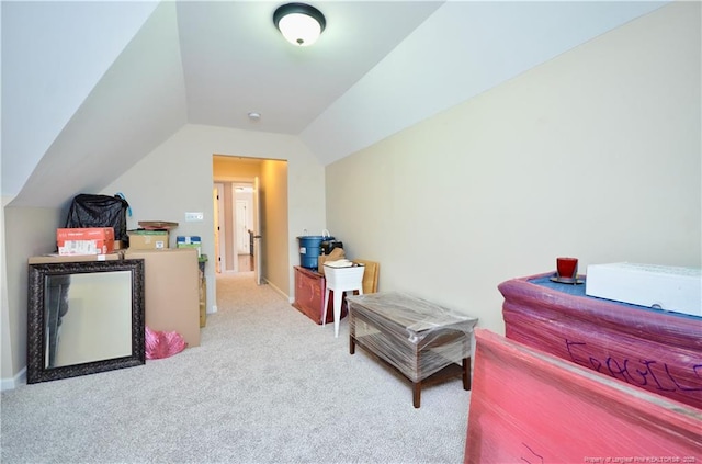 interior space featuring vaulted ceiling, carpet, and baseboards