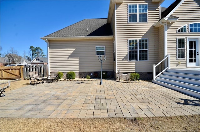 back of house with a shingled roof, crawl space, a patio area, and fence