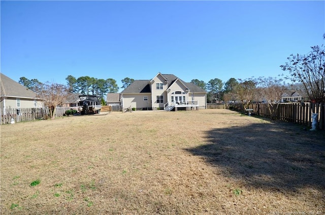 back of property featuring a yard and a fenced backyard