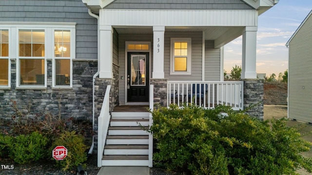 exterior entry at dusk with stone siding