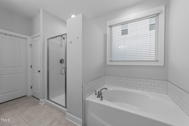 full bathroom with a garden tub, a shower stall, and tile patterned floors