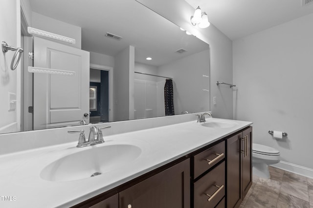 bathroom featuring visible vents, a sink, toilet, and double vanity