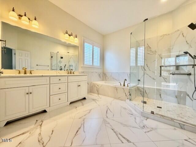 full bathroom with a marble finish shower, double vanity, a sink, a bath, and marble finish floor