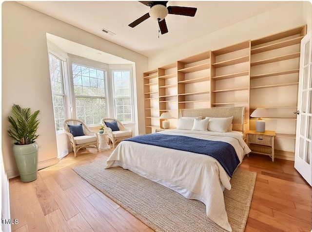 bedroom featuring visible vents, a ceiling fan, and wood finished floors