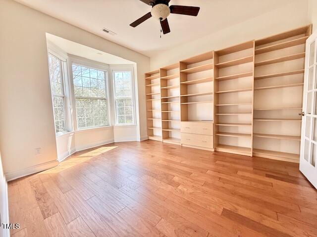 spare room with visible vents, a ceiling fan, light wood-type flooring, and baseboards