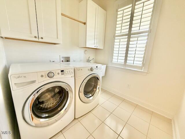 washroom with light tile patterned floors, baseboards, cabinet space, and independent washer and dryer