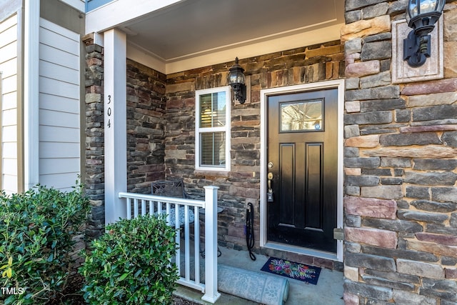 entrance to property featuring stone siding and a porch