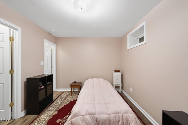 bedroom with baseboards and wood finished floors