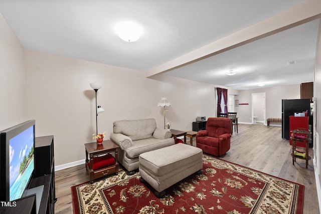 living area with baseboards and wood finished floors