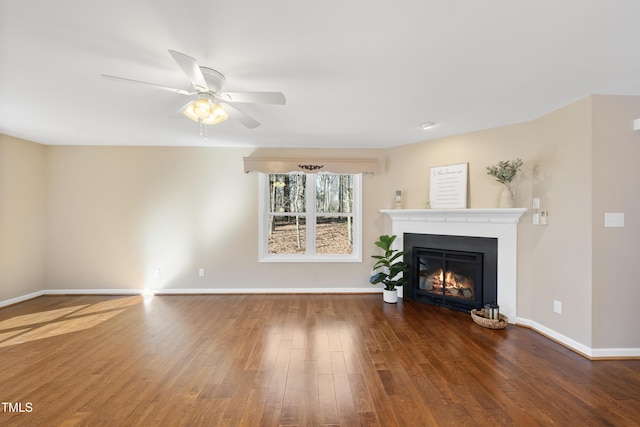 unfurnished living room with a glass covered fireplace, ceiling fan, baseboards, and hardwood / wood-style flooring