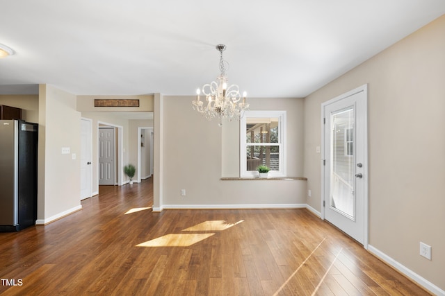 unfurnished dining area featuring baseboards and wood finished floors