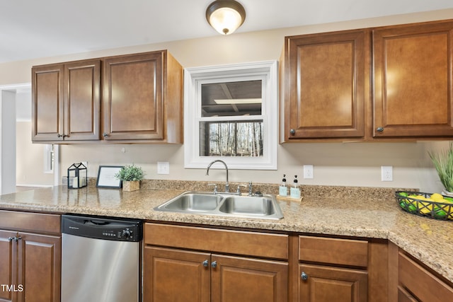 kitchen featuring dishwasher, brown cabinetry, and a sink