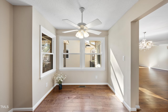 unfurnished dining area with hardwood / wood-style floors, plenty of natural light, visible vents, and baseboards