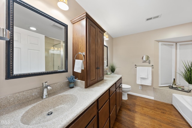 full bath featuring double vanity, a stall shower, visible vents, wood finished floors, and a sink