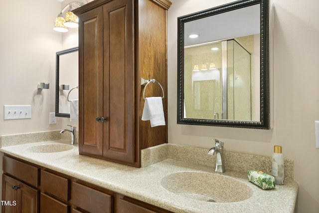 full bathroom featuring double vanity, a stall shower, and a sink