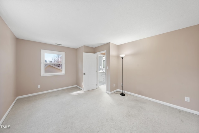 unfurnished room featuring baseboards, visible vents, and light colored carpet