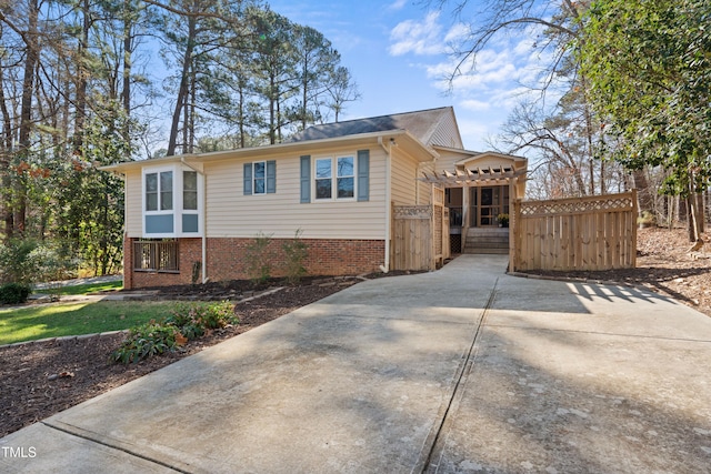 view of side of home with brick siding and fence