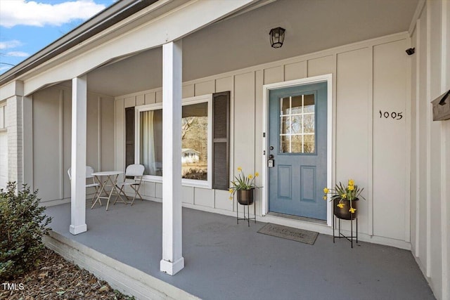 property entrance with covered porch and board and batten siding