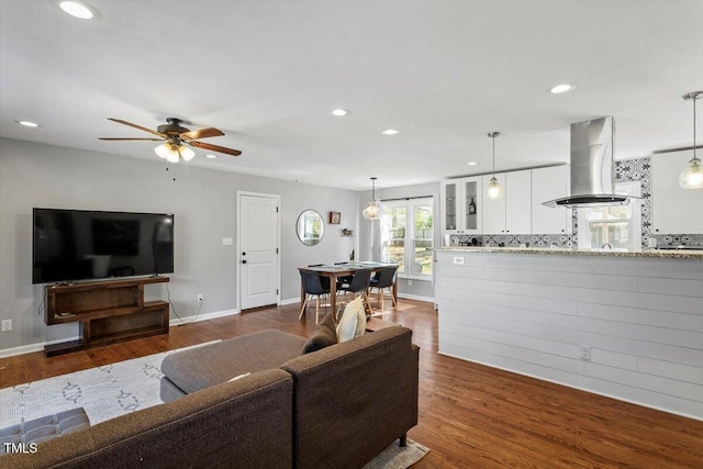 living area featuring a ceiling fan, recessed lighting, dark wood-style flooring, and baseboards