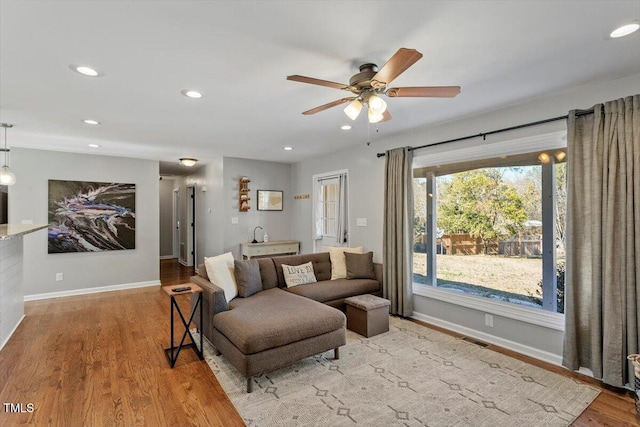 living area featuring visible vents, baseboards, wood finished floors, and recessed lighting