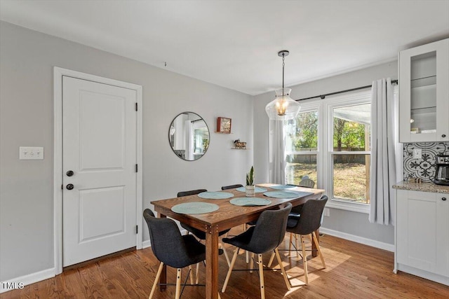 dining space featuring light wood-style flooring and baseboards