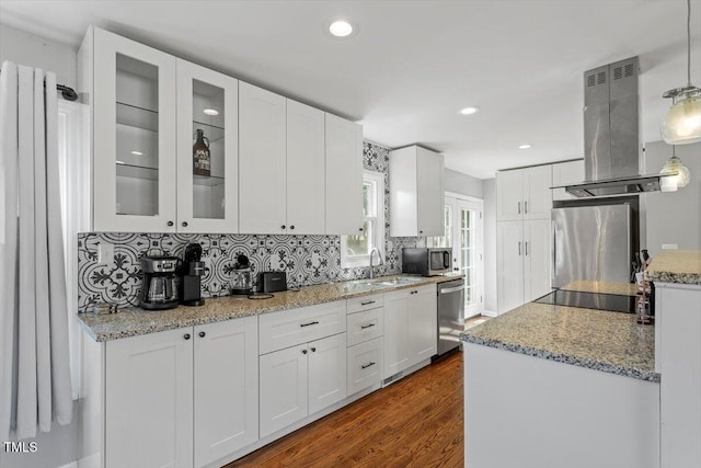 kitchen featuring dark wood-style floors, stainless steel appliances, backsplash, white cabinets, and island range hood