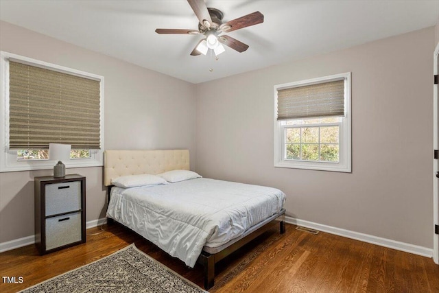 bedroom with visible vents, baseboards, and wood finished floors