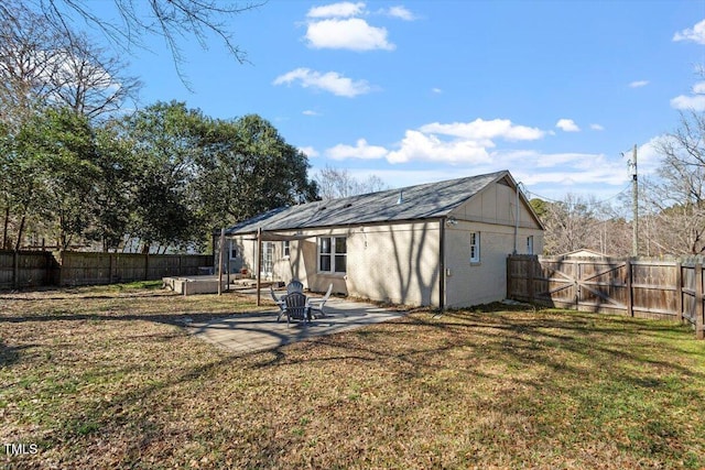 back of house featuring brick siding, a fenced backyard, a lawn, and a patio