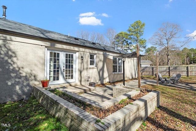 back of property with french doors, brick siding, a patio area, and fence