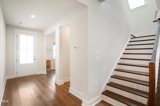 foyer featuring baseboards, visible vents, stairway, wood finished floors, and recessed lighting