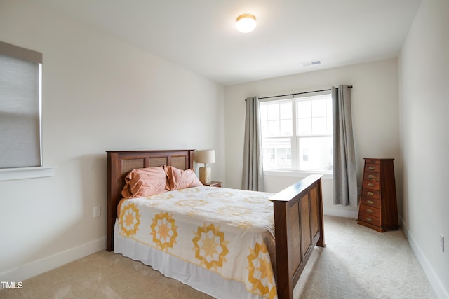 bedroom with light carpet, visible vents, and baseboards