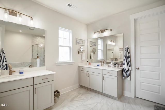 full bath with a stall shower, visible vents, two vanities, and a sink