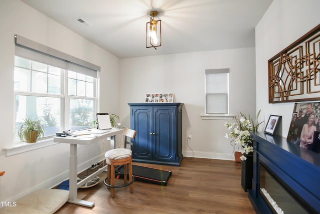 office area featuring dark wood-type flooring, visible vents, and baseboards