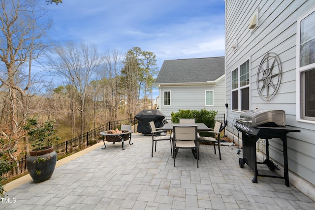 view of patio featuring an outdoor fire pit, outdoor dining area, a grill, and fence