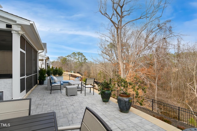 view of patio / terrace with outdoor lounge area, fence, and a sunroom