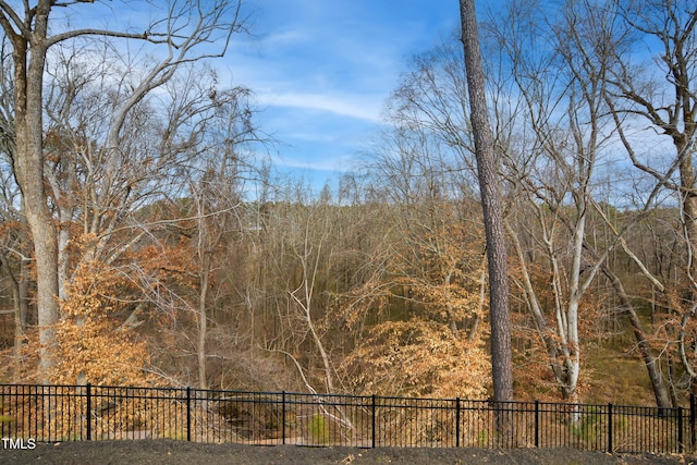 view of yard featuring fence and a view of trees