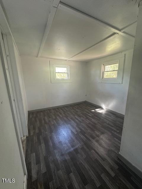 below grade area featuring dark wood-type flooring, a wealth of natural light, and baseboards