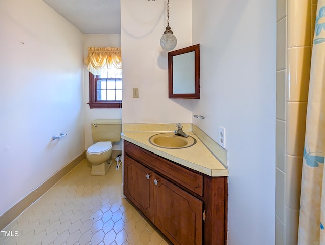 bathroom with vanity, tile patterned floors, toilet, and baseboards