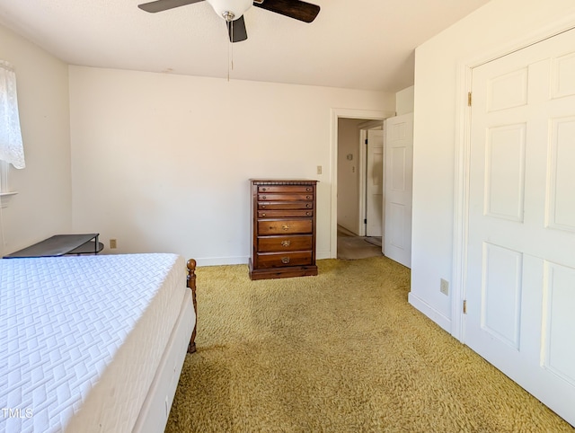 carpeted bedroom featuring baseboards and a ceiling fan