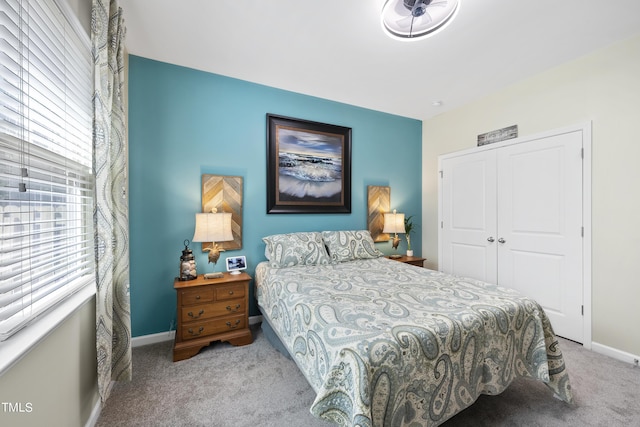 bedroom with a closet, carpet flooring, and baseboards